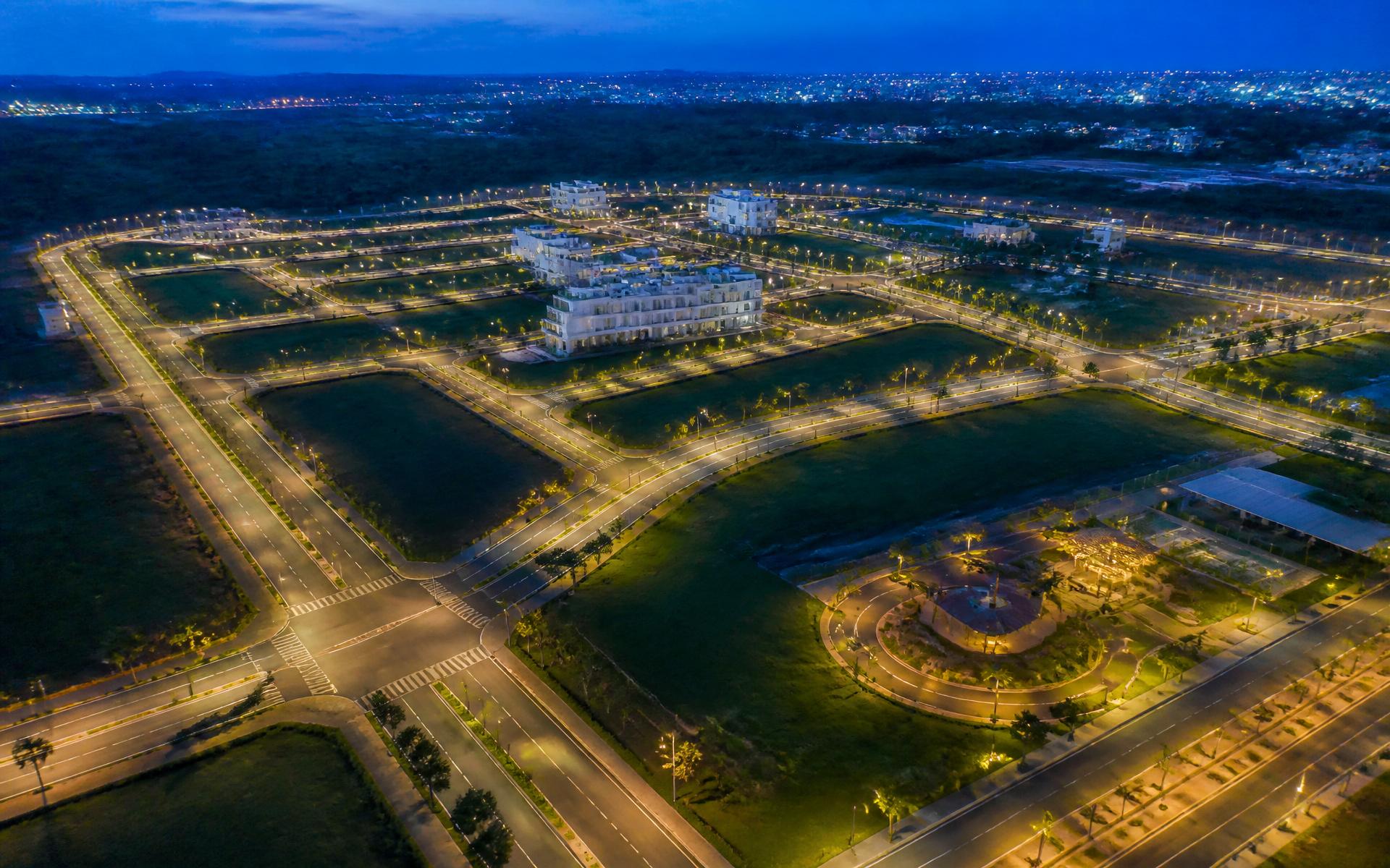Aerial twilight view of an illuminated plotted township